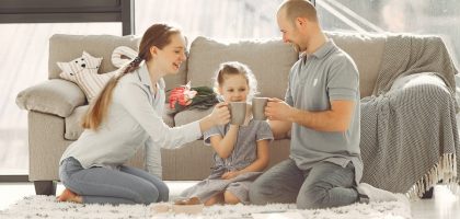 A joyful family enjoying quality time and coffee in a bright living room, symbolizing love and togetherness.