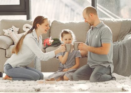 A joyful family enjoying quality time and coffee in a bright living room, symbolizing love and togetherness.